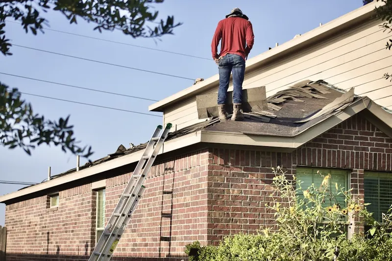 Professional roofer working on a residential roof in Blendon
